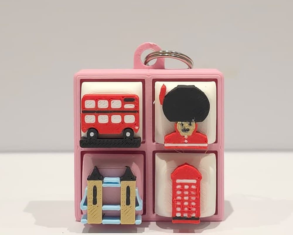 A Sakura Pink 2×2 London clicker with a London bus, a King's Guard, Tower Bridge and a red phone box on its four keys